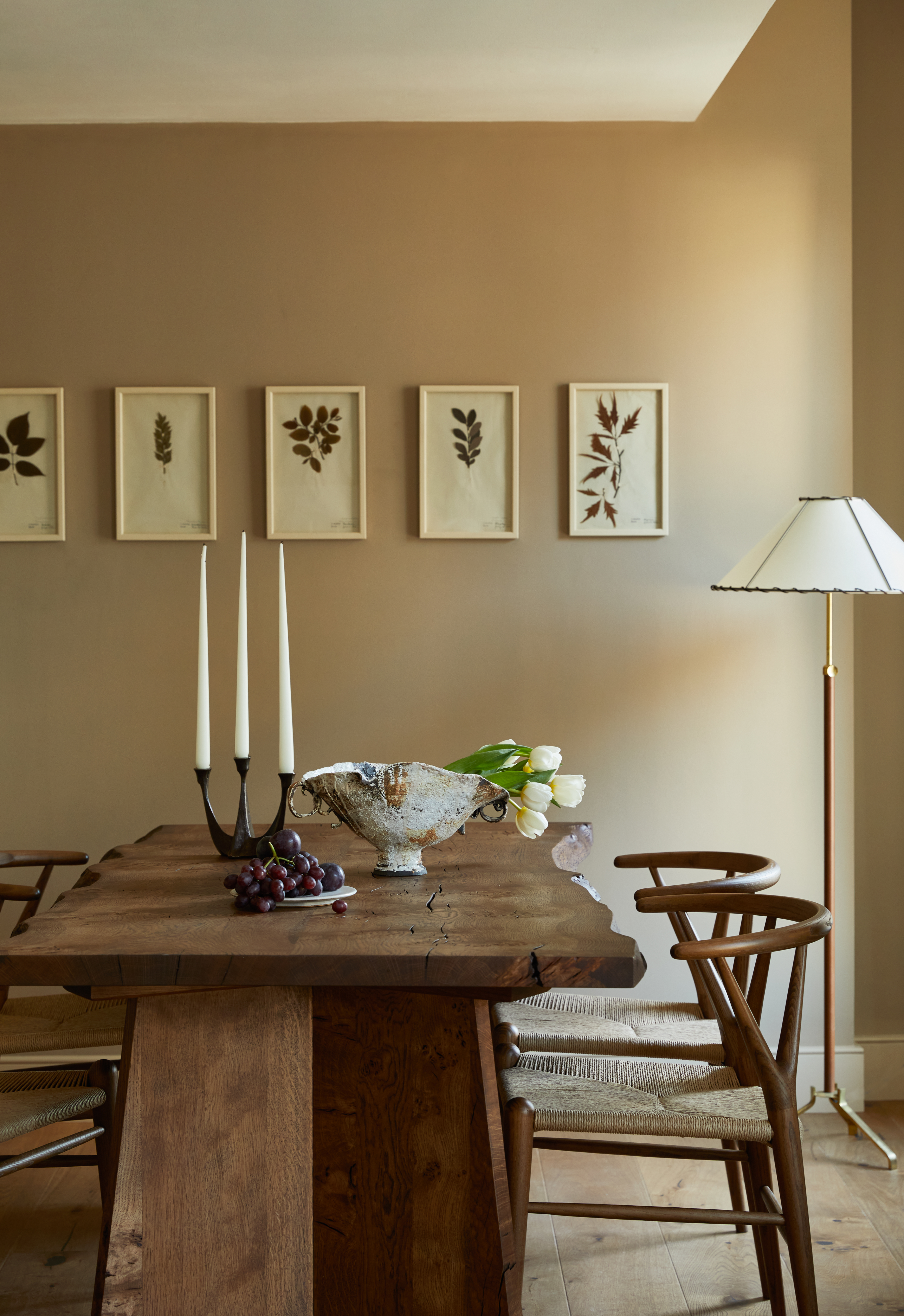 a dining table with a wooden slab table, and warm, earth toned walls