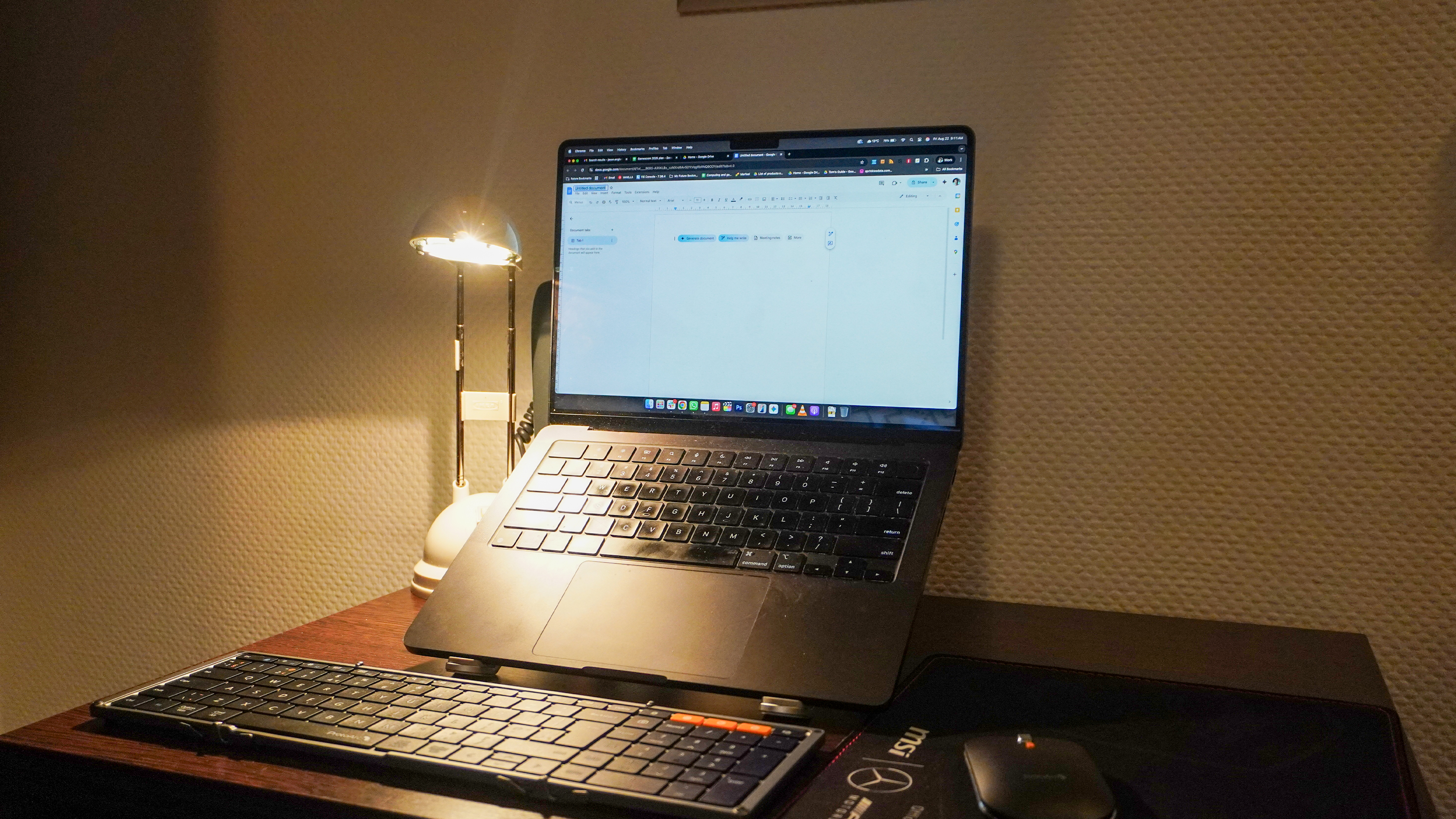 ProtoArc XKM01 keyboard next to a laptop on a stand