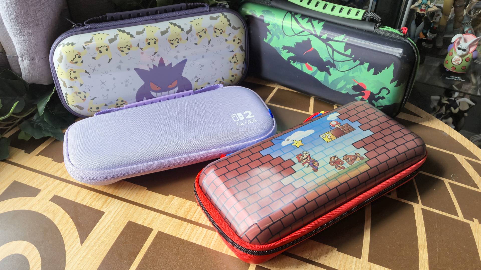 Photo of a collection of Hori and Turtle Beach Switch 2 cases on a wooden coffee table.