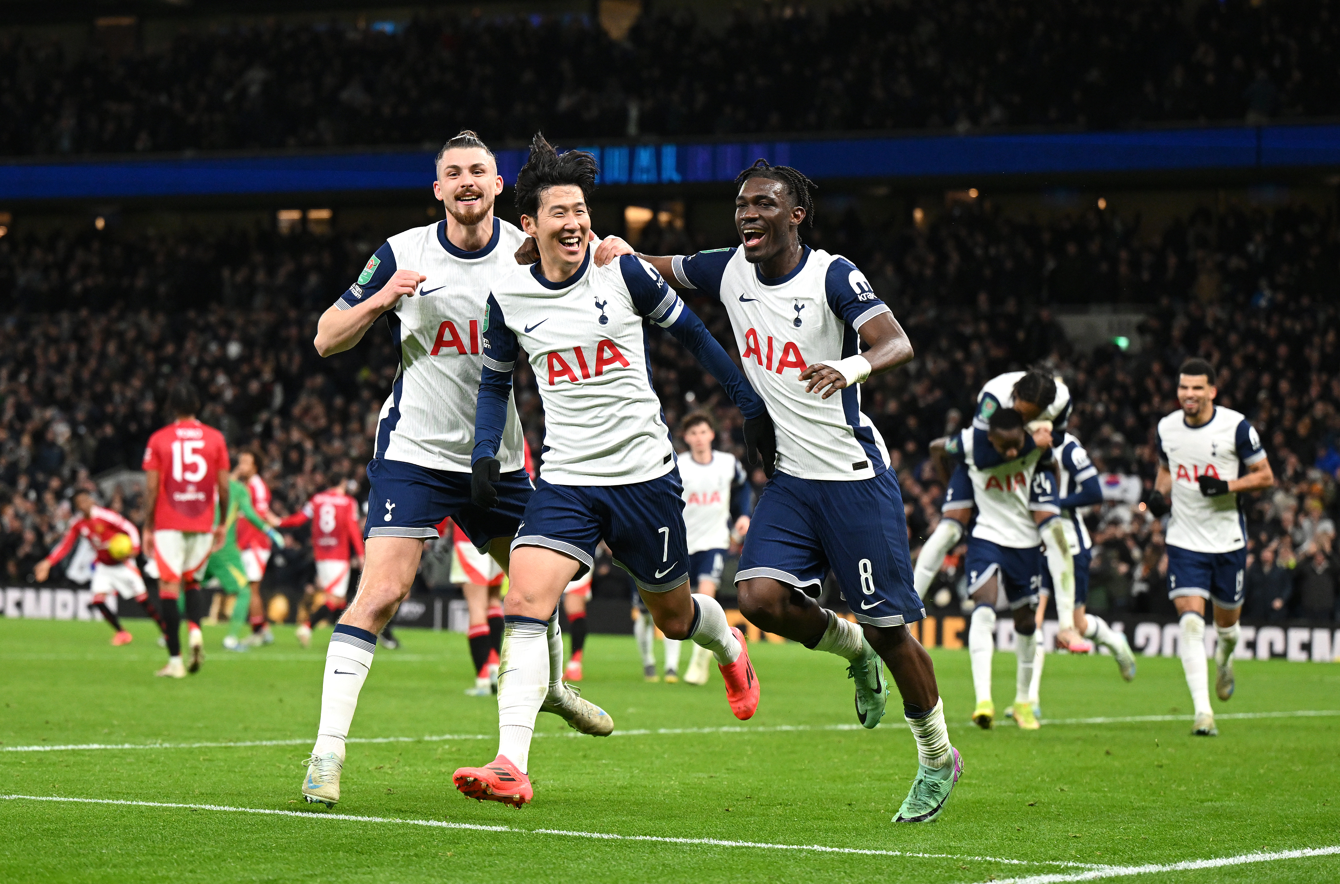 Son Heung-min celebrates with Tottenham team-mates Radu Dragusin and Yves Bissouma after scoring directly from a corner against Manchester United in the League Cup in December 2024.