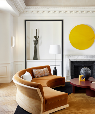 White living room with bright yellow accents and burnt orange couch