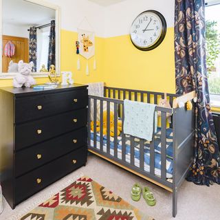 boys bedroom with yellow painted wall and cot