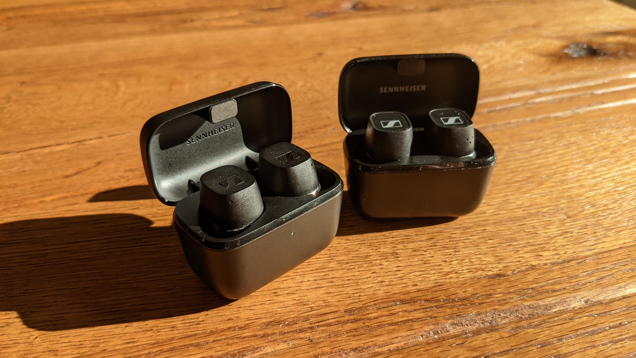 Sennheiser CX True Wireless links und Sennheiser CX 400BT mit Cases nebeneinander auf einem Tisch