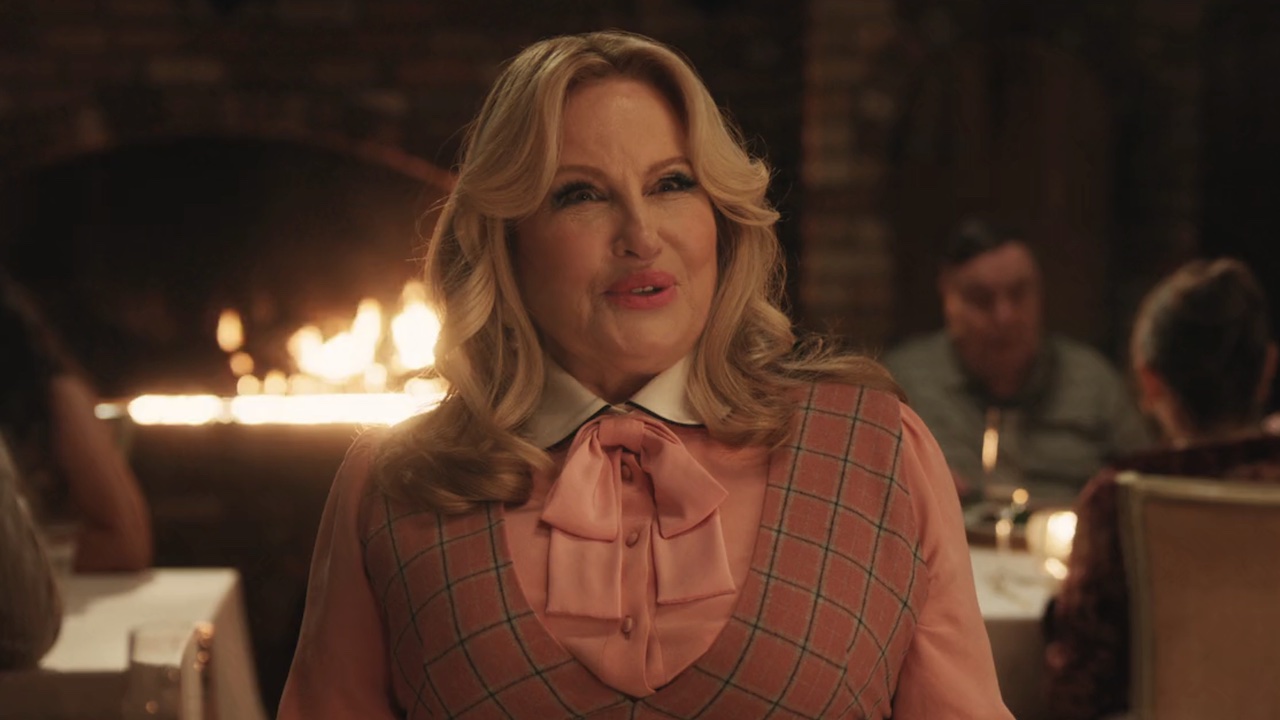 Jennifer Coolidge looking impressed while seated at dinner with Nitwit in A Minecraft Movie