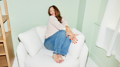 a woman sitting on a white accent chair