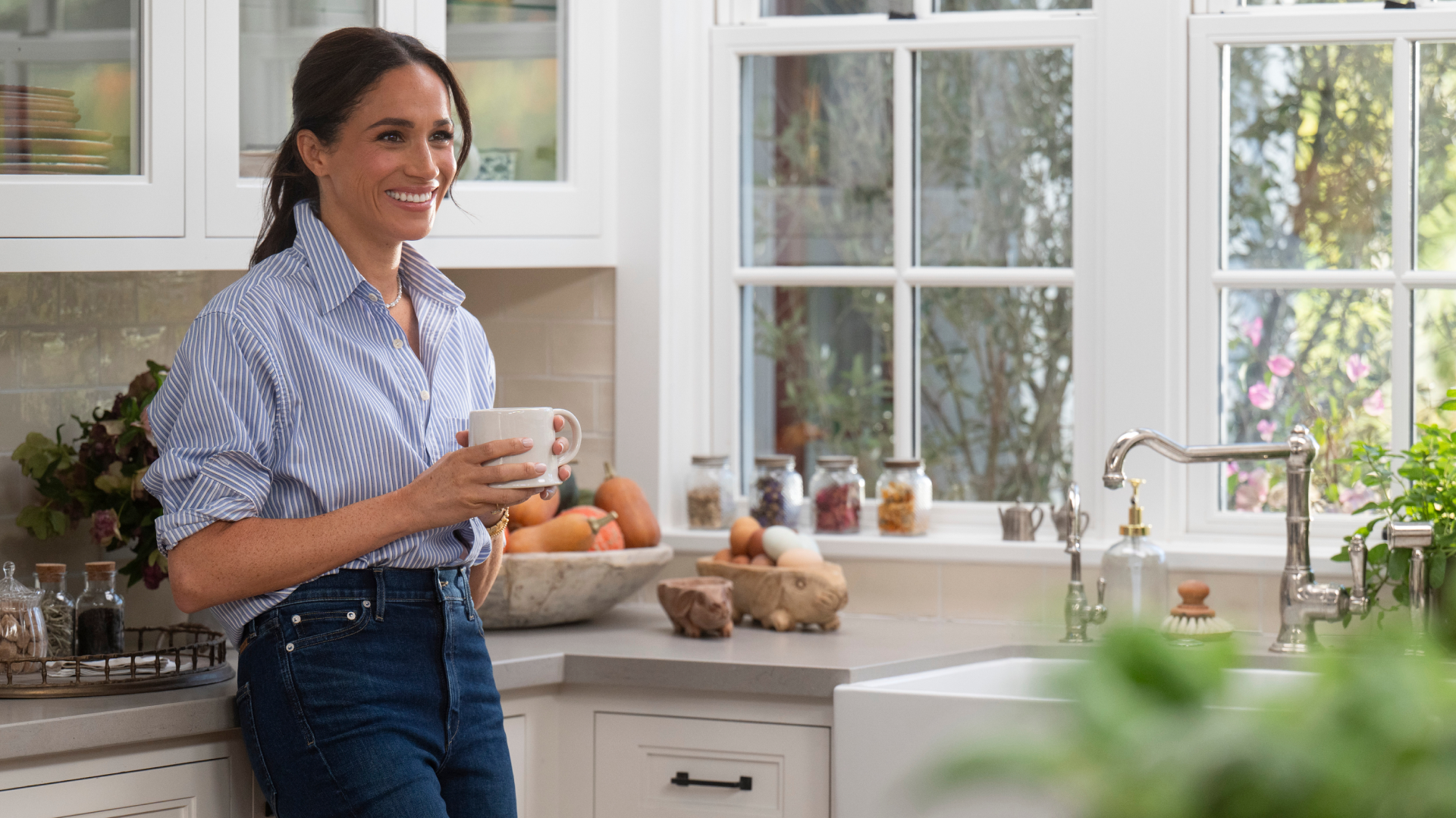 Meghan Markle standing in a kitchen