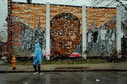 Rain falls in front of a Freddie Gray mural in Baltimore.