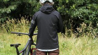 Photo of the back of the Rapha Trail Lightweight jacket being worn