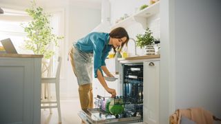 Woman loading a dishwasher in the kitchen