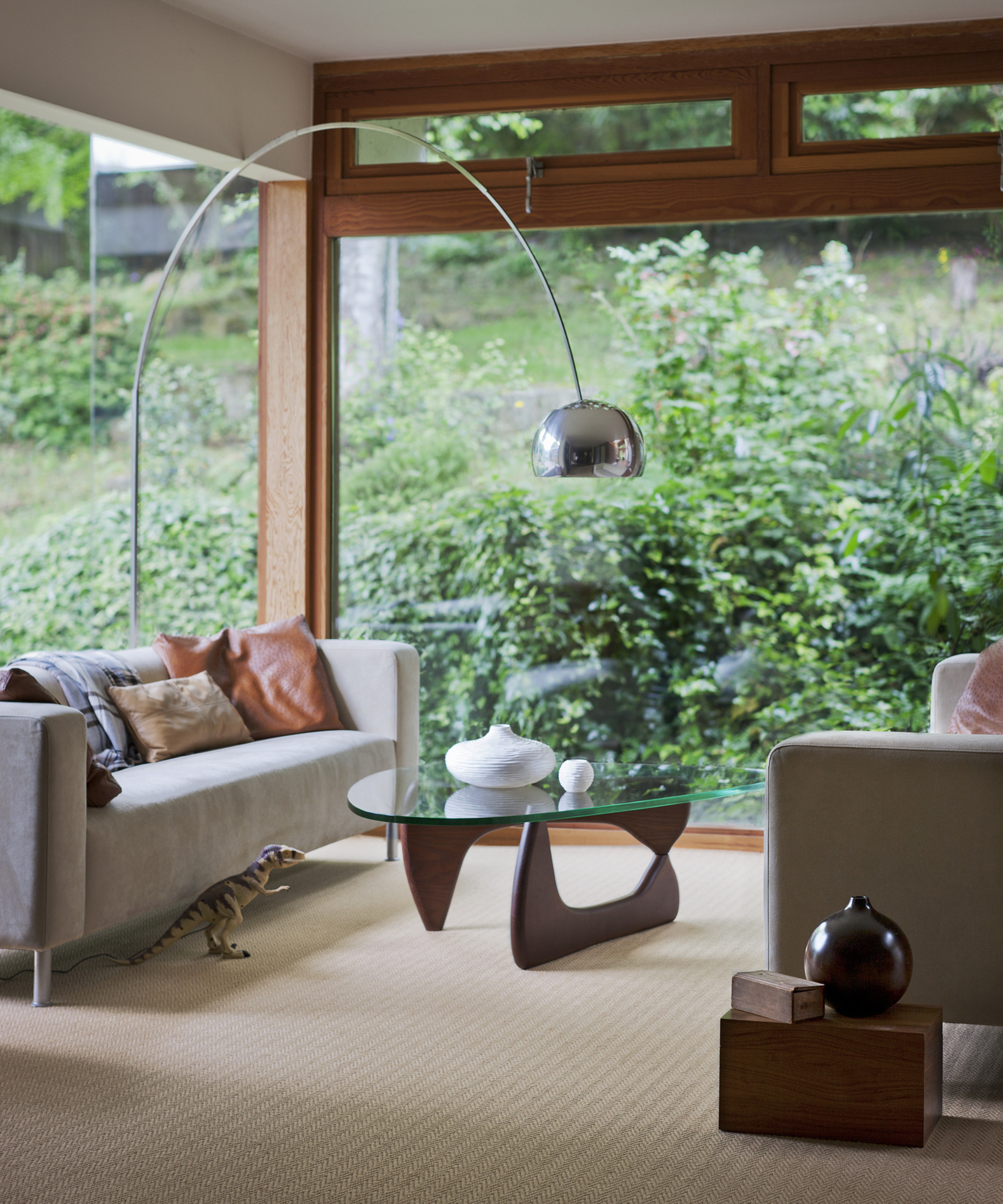 Living room with beige carpet and two sofas opposite each other with floor to ceiling windows to the left back back