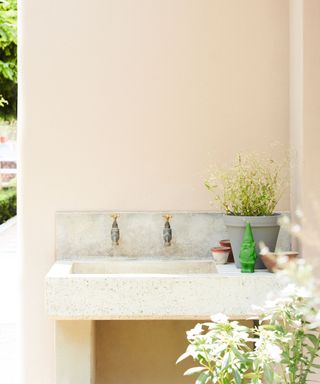 Outdoor sink set into a pink wall