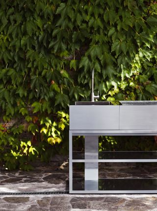 outdoor sink ideas: steel basin against leafy wall