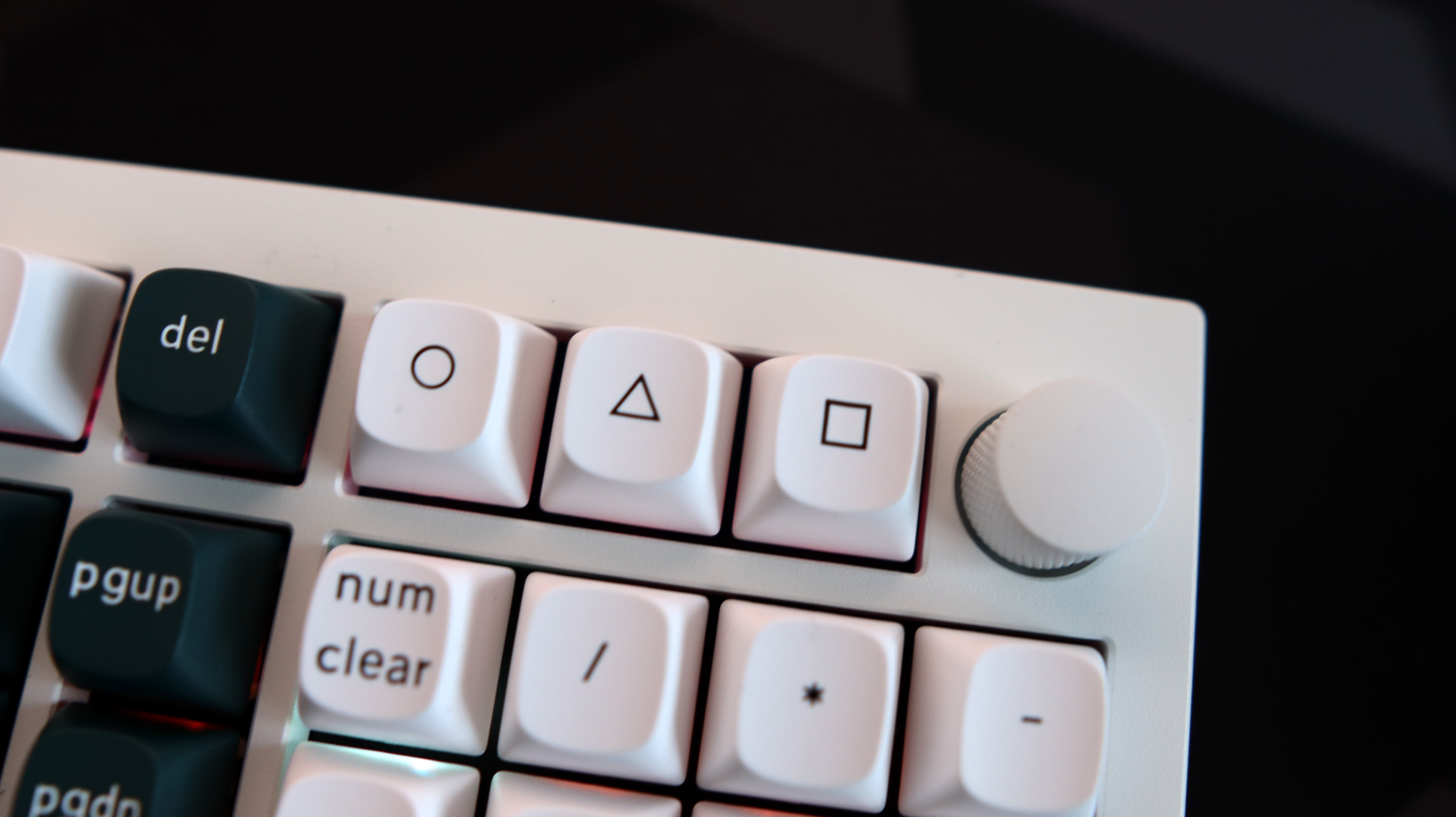 A Keychron Q5 HE gaming keyboard on a desk with white and blue keycaps.