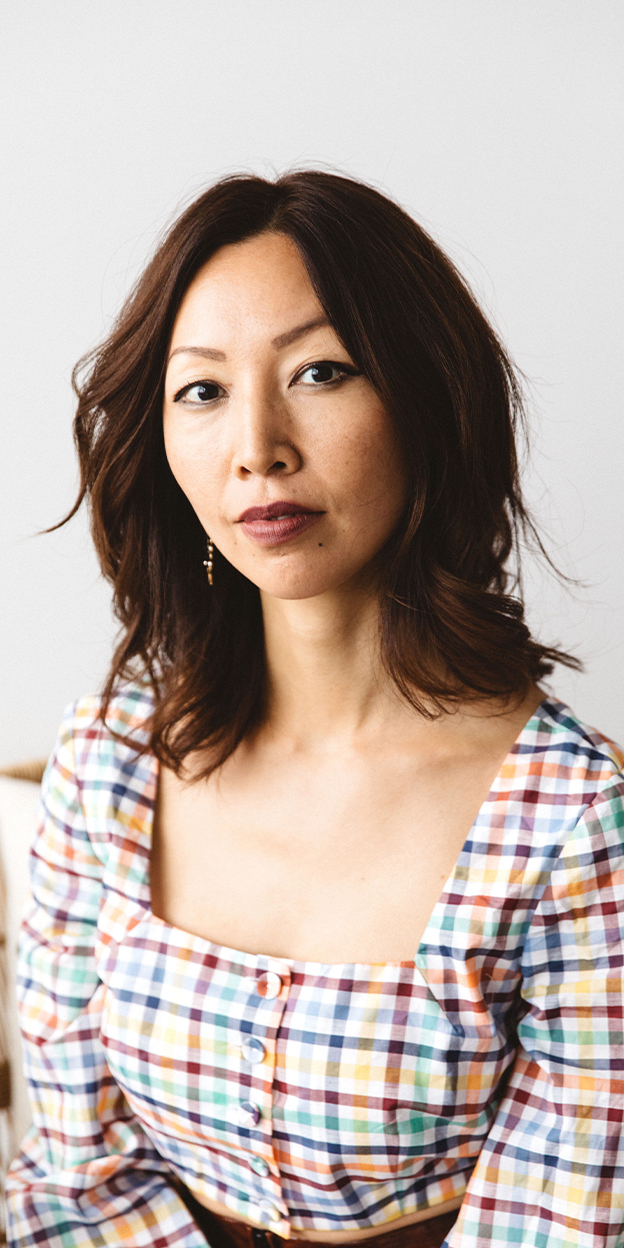 a woman with a lob wearing maroon lipstick and a checkered dress