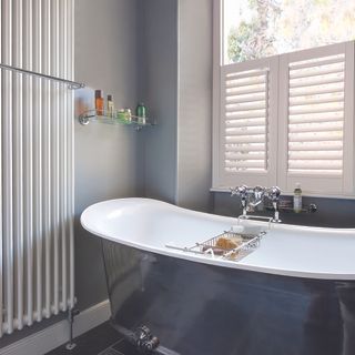 a bathroom window with vinyl shutters