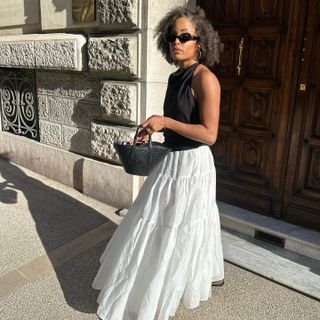 Woman in black top and white full skirt