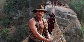 Indiana Jones about to cut a rope bridge