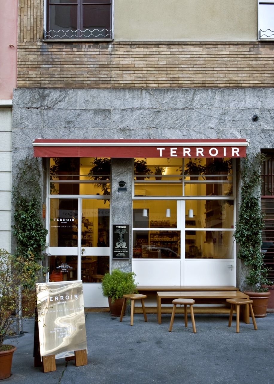 The shop front of a local grocer in Milan features an industrial chic vibe.