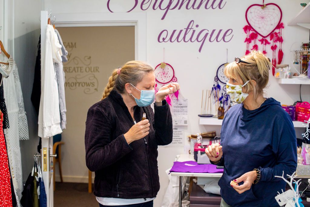 Woman smells perfume through a mask