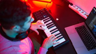 Overhead image of man playing a MIDI keyboard