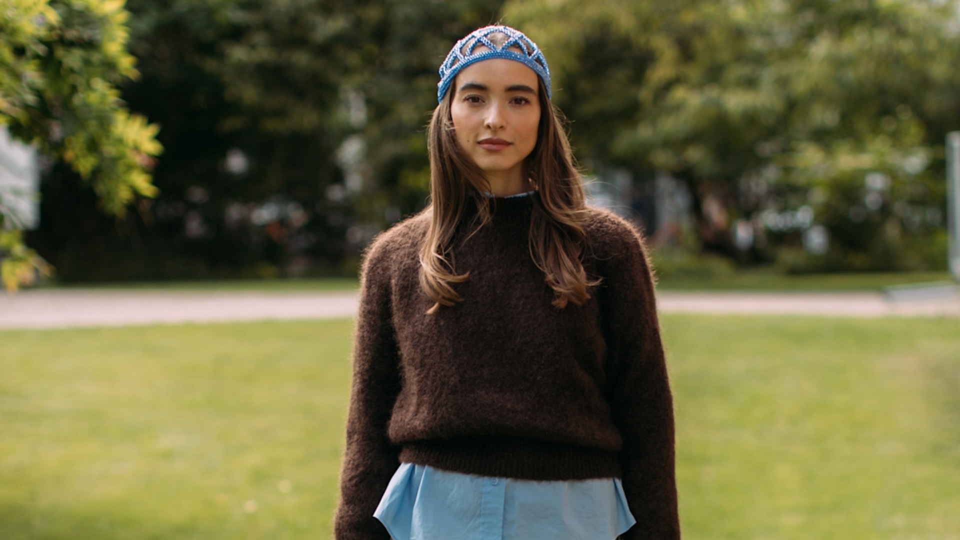 woman wearing a brown sweaterand a blue knit hat in Copenhagen.