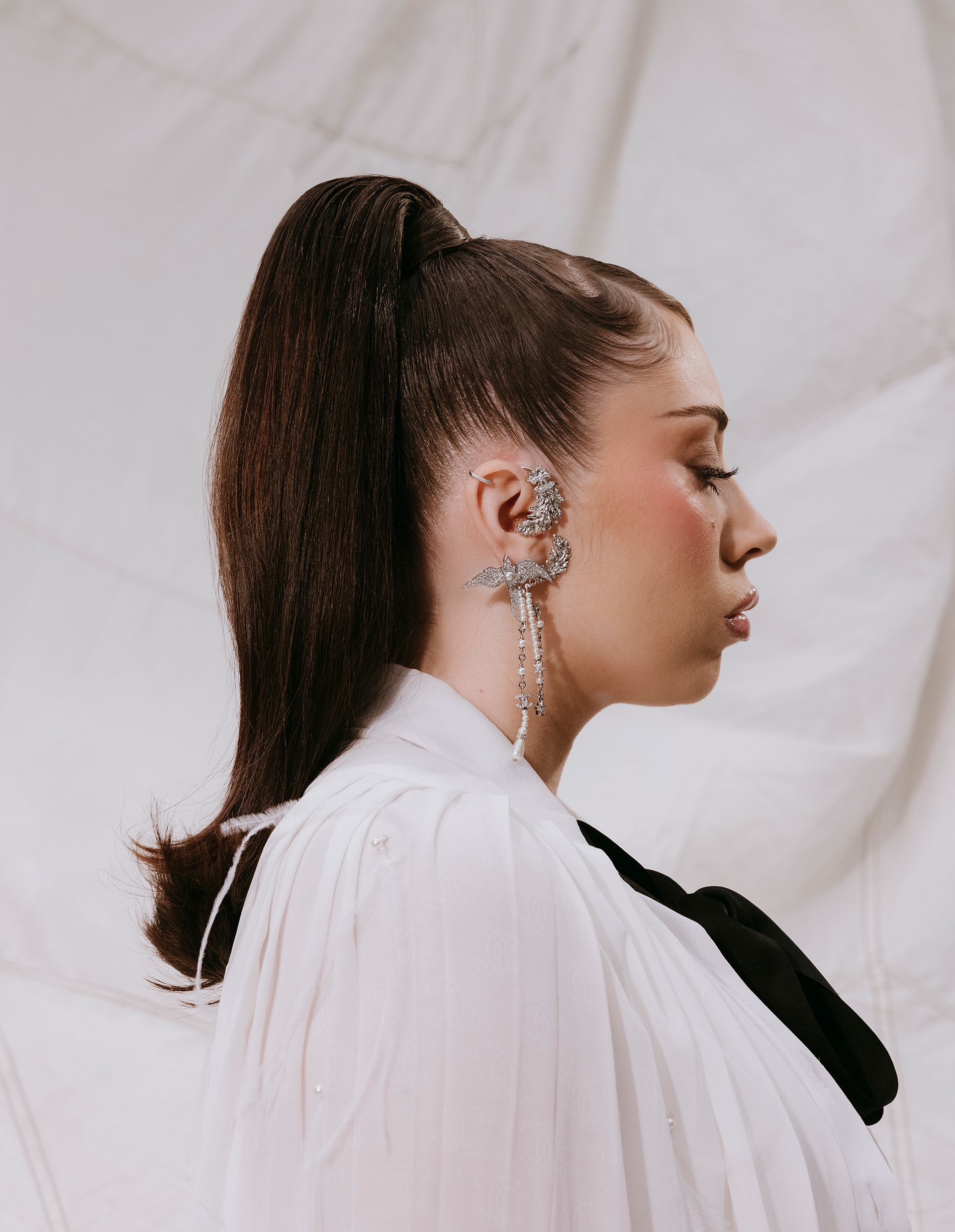 Kali Uchis in profile with a high ponytail