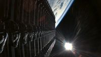 a row of rectangular satellites seen against the blackness of space and the curvature of earth below them