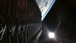 a row of rectangular satellites seen against the blackness of space and the curvature of earth below them