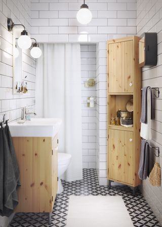 small bathroom with white subway tiles and wooden bathroom storage
