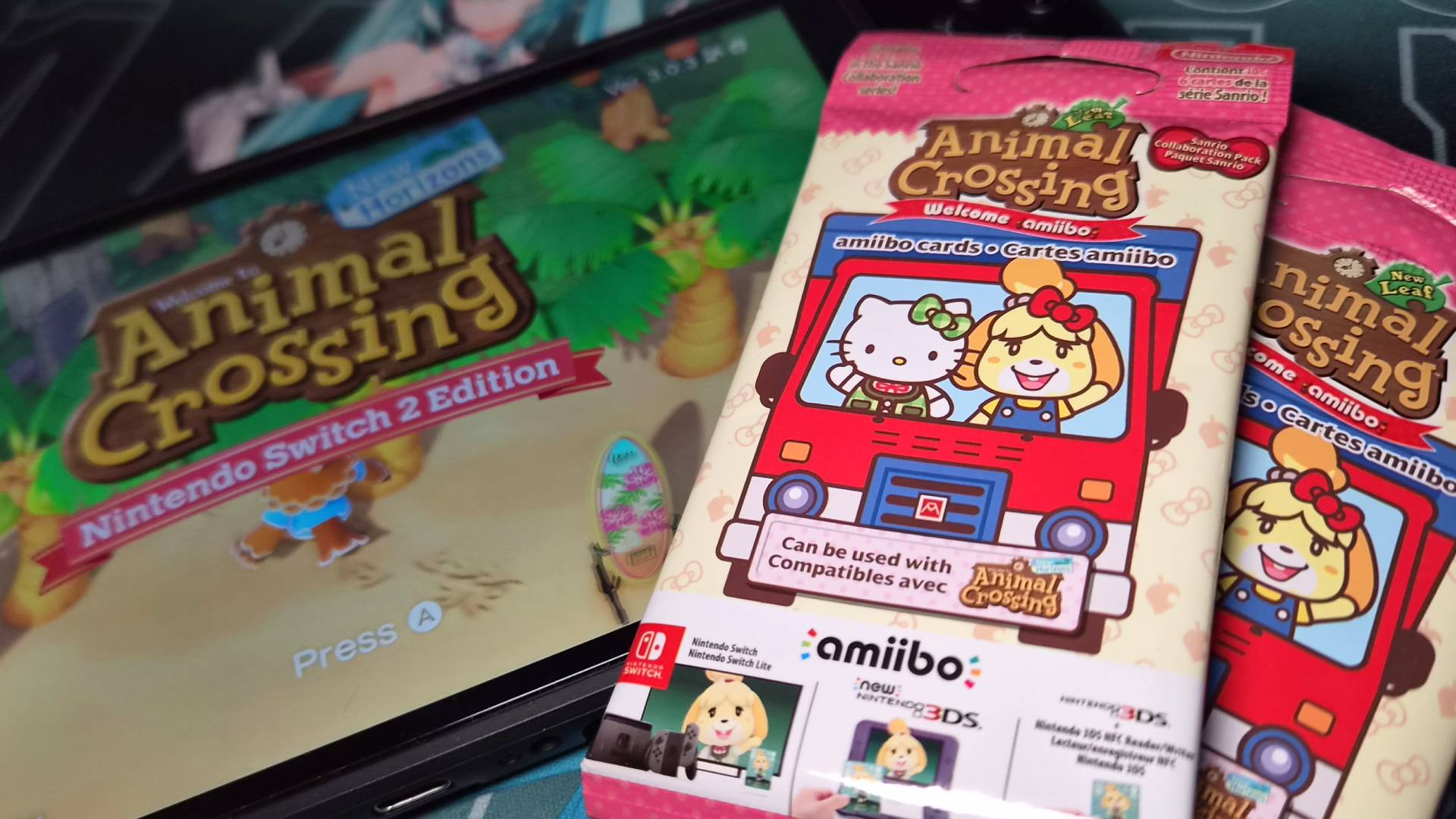 Photo of two packs of Animal Crossing Sanrio amiibo cards sitting on a Nintendo Switch 2.