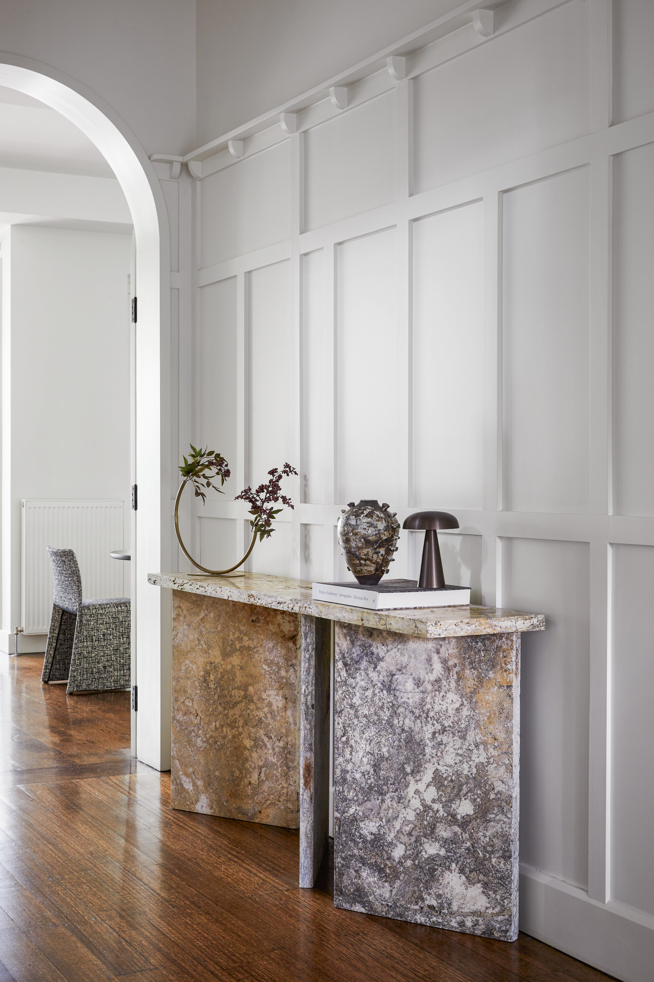 Hallway with white panelled walls and grey and white marble console table