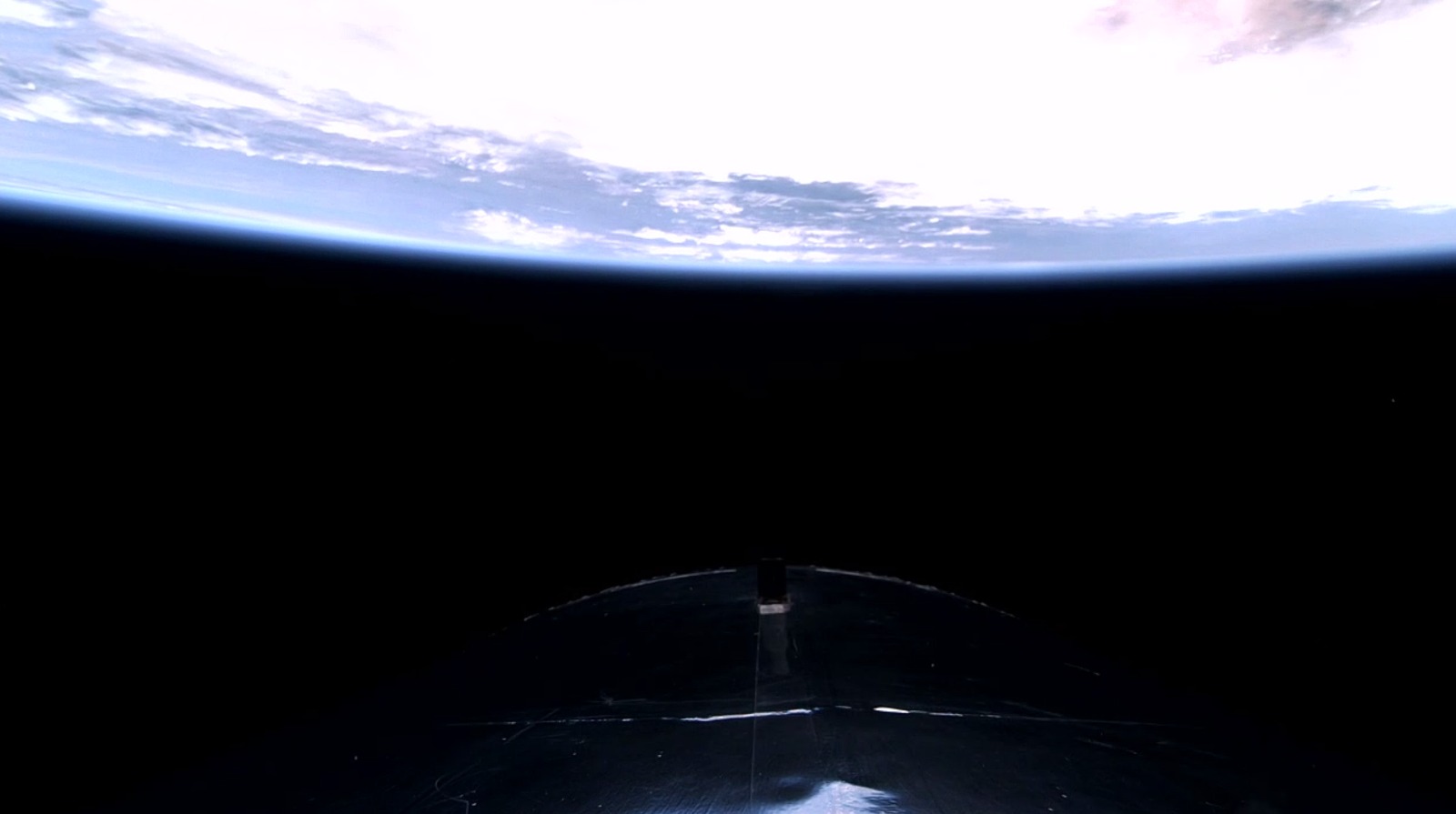 Een zicht op de aarde achter de VSS Unity van Virgin Galactic tijdens de Galactic 07-missie.