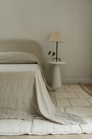 A bed with light linen sheets