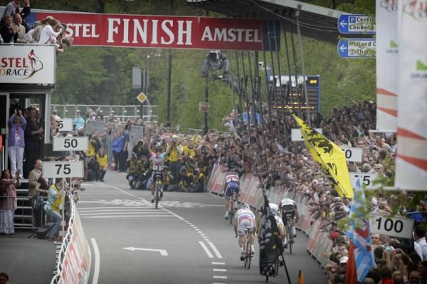 Gilbert crosses the line with his arms raised