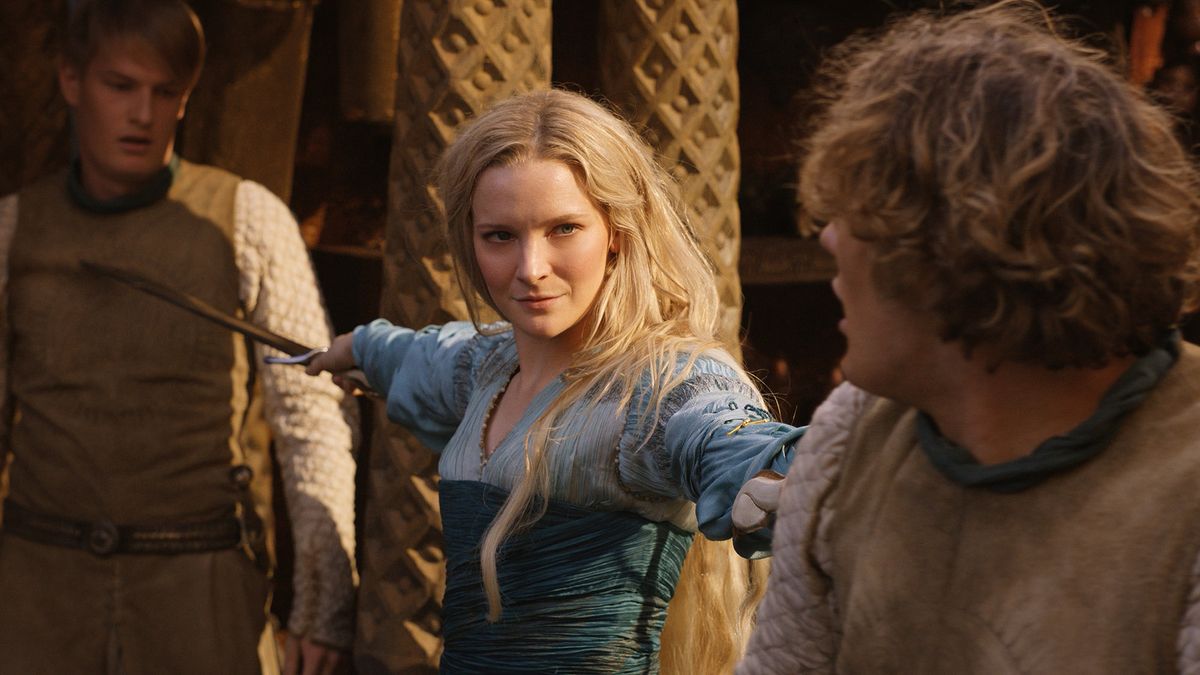 Morfydd Clark (Galadriel) holds blades to two men in The Rings of Power