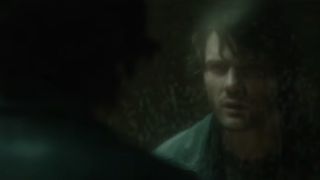 Jeremy Irvine looks into a dirty bathroom mirror in Return to Silent Hill.