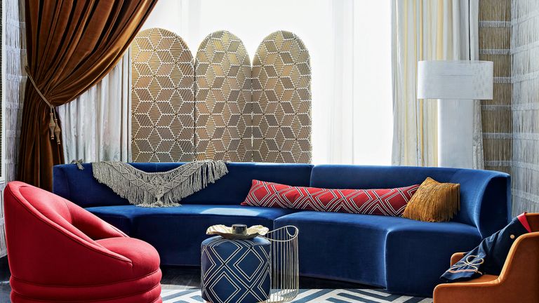 橙色天鹅绒窗帘和深蓝色沙发的客厅