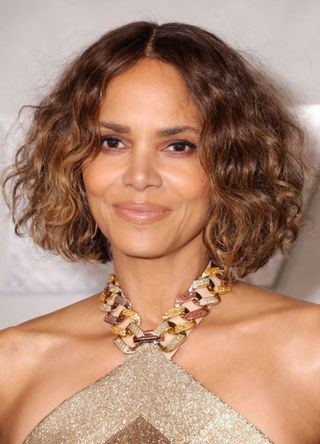 Actress Halle Berry in a gold and braided halterneck dress