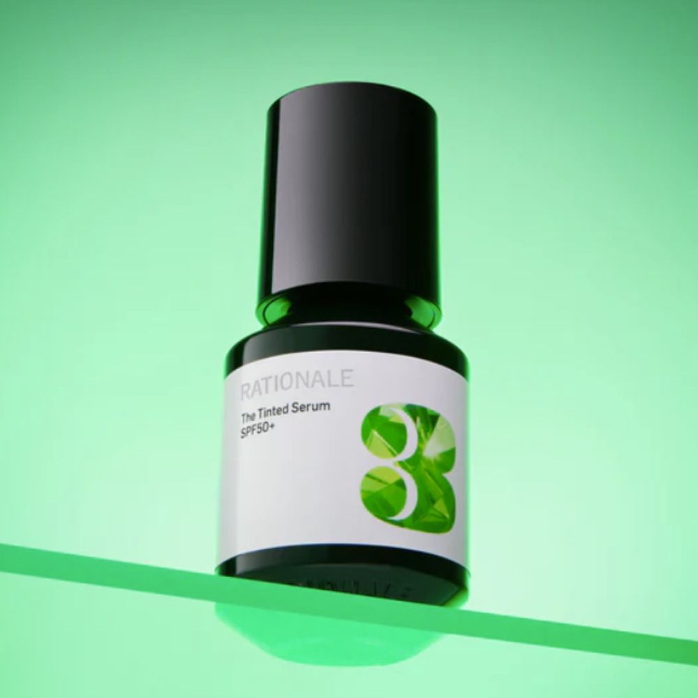 Bottle of Tinted Serum from Rationale skincare on a green background