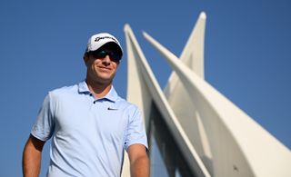 Guido Migliozzi walks at the Dubai Invitational whilst wearing a pair of sunglasses and blue top