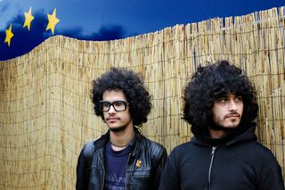 The Mars Volta standing in front of a bamboo fence