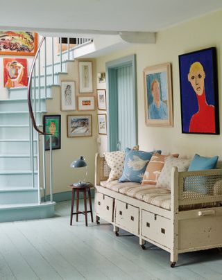 Hallway with painted floor and staircse and gallery wall in Vanessa Arbuthnott's converted cow barn