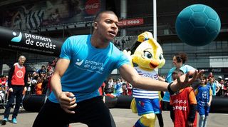 Kylian Mbappe takes part in a football match with children at the Stade de France alongside former Arsenal manager Arsene Wenger in 2019.