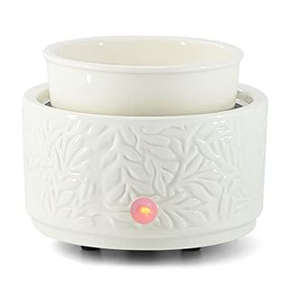 A white ceramic oil burner in a warming device, with a red indicator light on the front