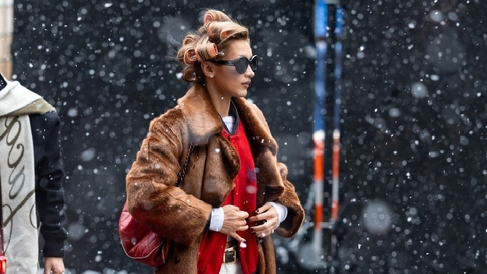 Bella Hadid in New York City wearing a fur coat and black sneakers