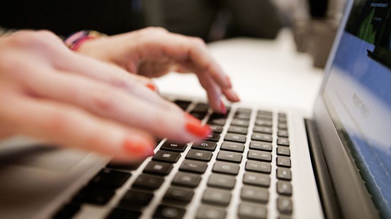 Woman typing on laptop keyboard