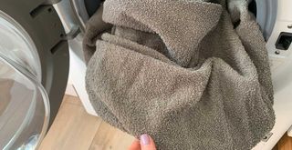 washing machine with grey towels to show how to soften towels by washing with white vinegar