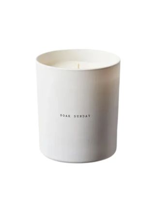 a white candle jar reads "Soak Sunday" placed against a white background.