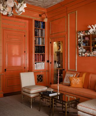 room with bright orange panelled walls, orange sofa, eclectic decor