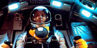 a man in a spacesuit inside a cockpit